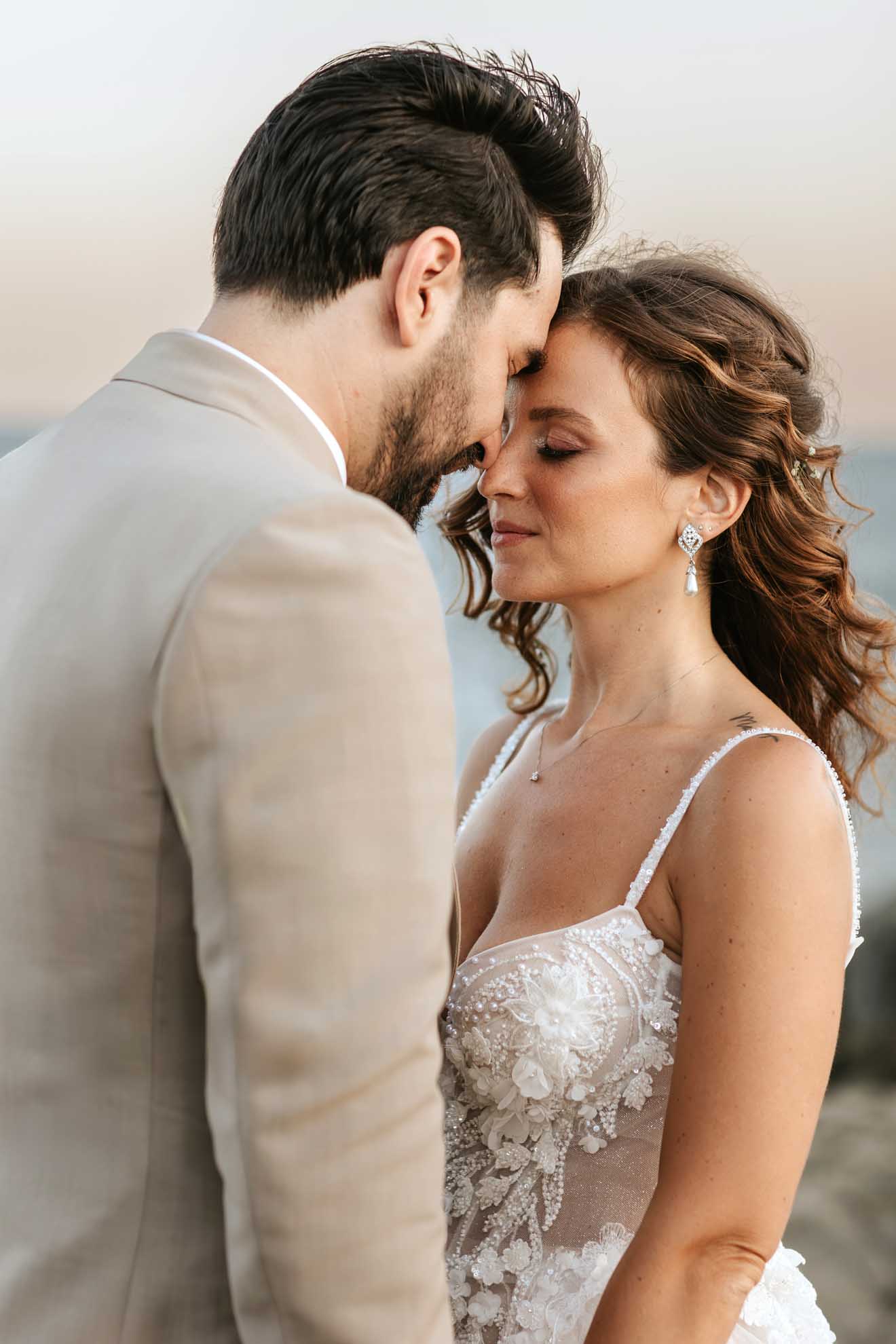 Simone e Chiara, in riva al mare, esprimono amore e armonia con un look studiato per riflettere l’essenza del loro matrimonio.