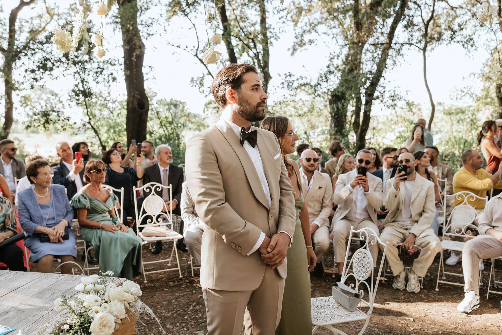 Simone, in un abito sartoriale color sabbia, celebra il suo matrimonio con Chiara in un’atmosfera naturale e intima nel bosco.